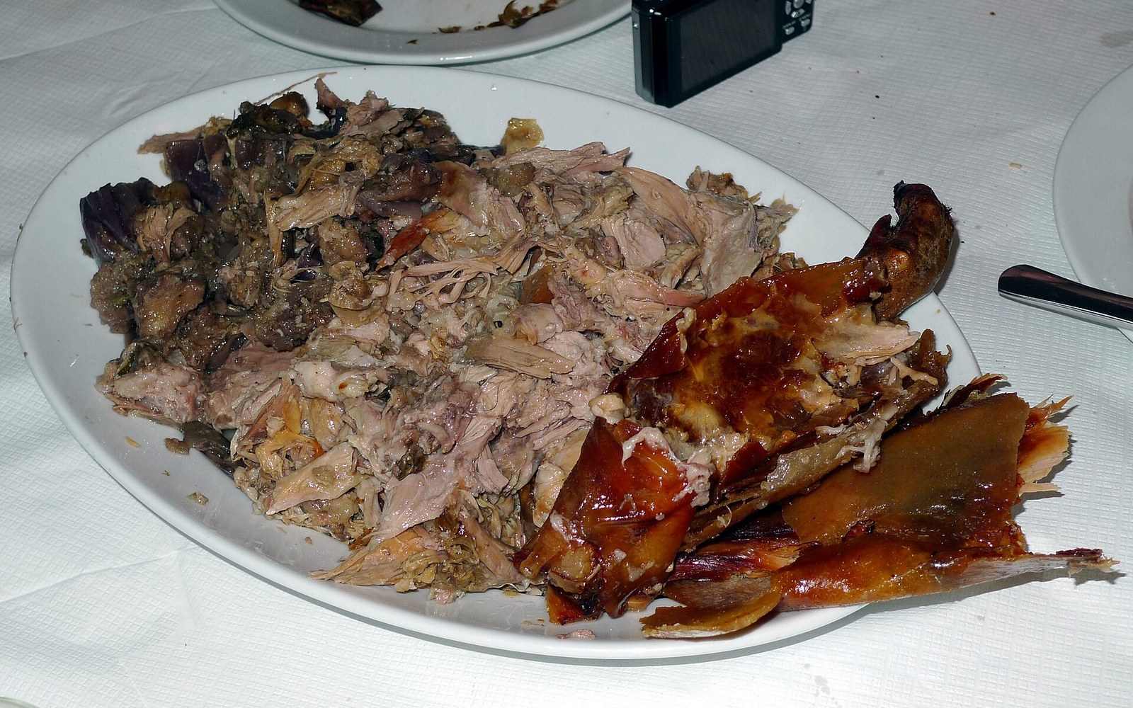 Shredded roast pork with crispy crackling served on a white oval plate