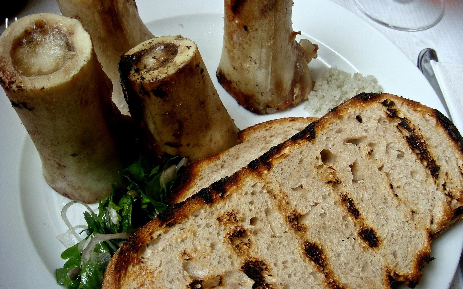 Roasted marrow bones served with grilled bread, parsley salad, and coarse salt